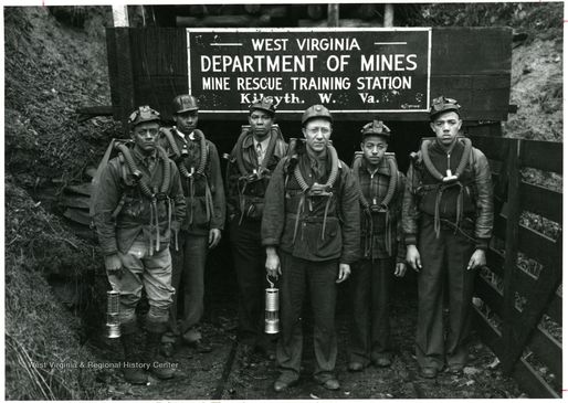 A black-and-white photograph of miners in front of a WV Department of Mines sign