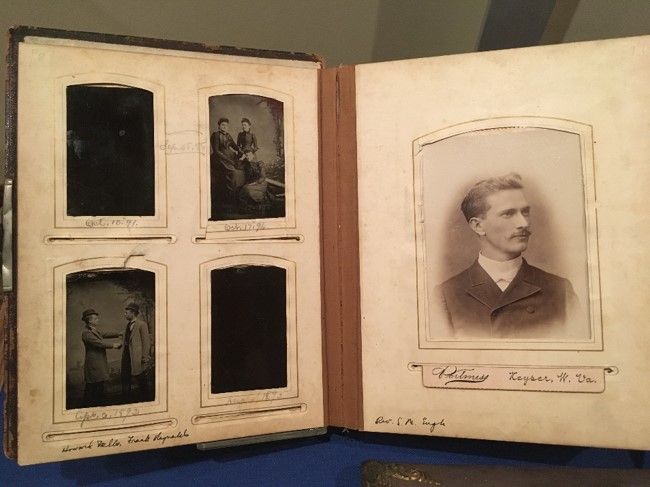 A two-page spread of a photo album: on the right are four small  images, and on the right is one large portrait of a man with short hair and a mustache looking to his left.