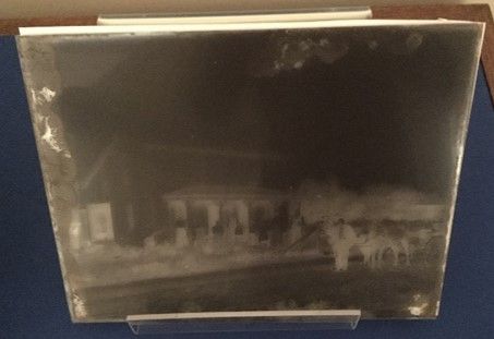 A glass plate negative of a street with horses and a cart