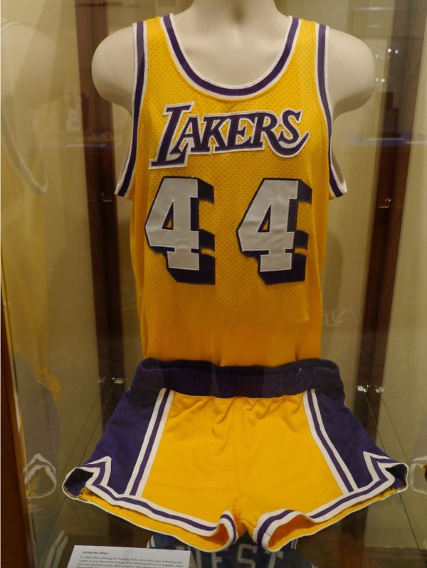 A yellow and purple lakers uniform displayed in a glass case, it is number 44