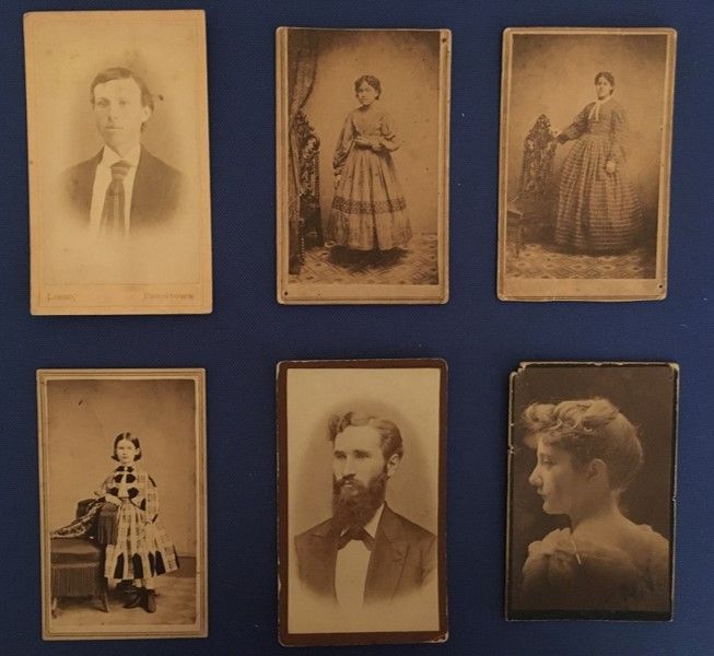 A selection of 6 CDV images: a young white man wearing a tie, woman standing in a long dress, a woman standing with her hand on a chair, a young girl in a dress, a man with a long beard, and a young woman with her back to the camera, facing to the side.