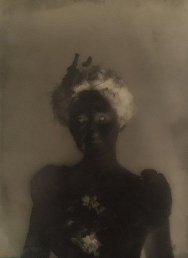 A glass plate negative of a woman with curly hair wearing a hat