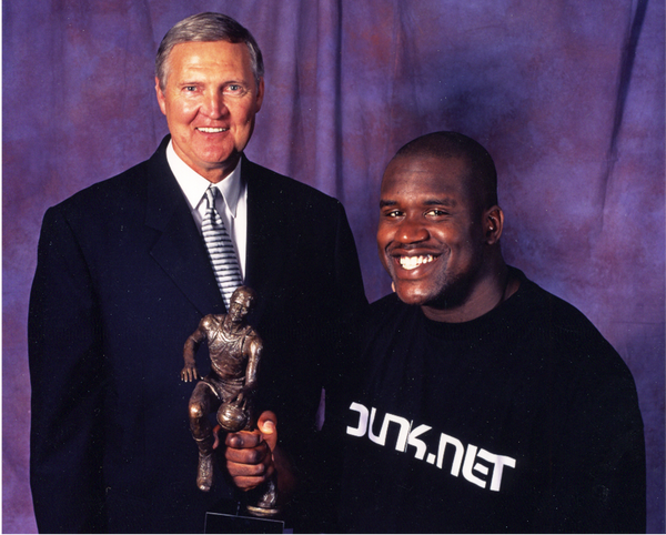 Jerry West and Shaquille O'Neal posing in front a purple curtain background