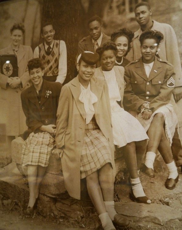 A group of African American students wearing school clothes and smiling at the camera