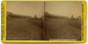 Stereograph of a large field with a large building in the distance.