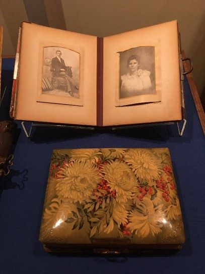 A photo album, with a portrait of a man on the left page and a portrait of a woman in a white dress on the right. 