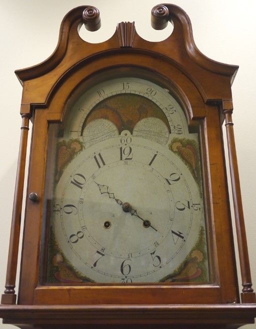 Strother family grandfather clock, made of a warm-toned medium brown wood. 