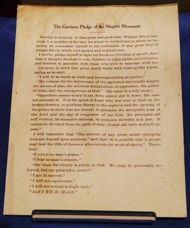 A document in a clean, official script, slightly yellowed, displayed on a blue background. The title reads "The Garrison Pledge of the Niagara Movement"