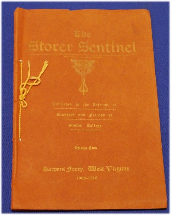 A bright orange book with gold text and decoration reading "The Storer Sentinel"
