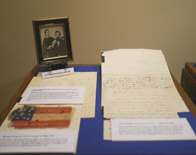 A selection of letters and photos from John J. and Anna Kennedy Davis displayed on a blue cloth