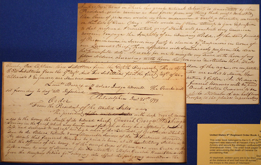 Three yellowed documents with cursive writing displayed against a blue background