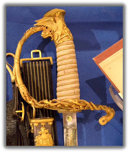 the hilt of the sword, with an ornate gold design that wraps around into the handle