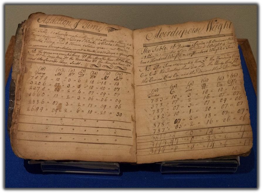 Faded workbook bound in bark in 1765 for teaching math. The pages are worn and stained 