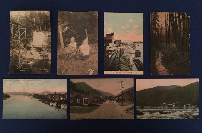 A selection of 7 postcards: wide open mountain landscapes, city streets, two toddlers sitting together outside