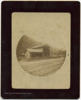 Image of a small building sitting next to the railroad tracks.