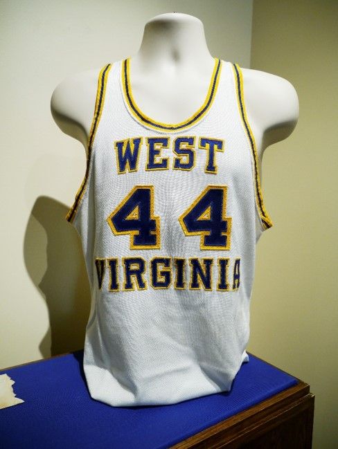 A WVU basketball jersey with the number 44. It is a white tank with dark blue text and trimmings and yellow outlines