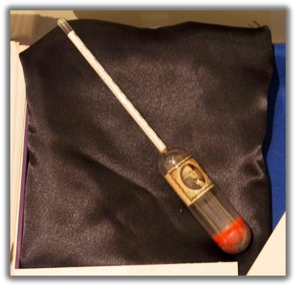 a hydrometer lays against a black cloth background