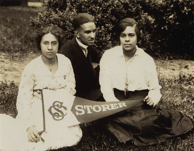 Photograph of three Storer College students holding a Storer pennant