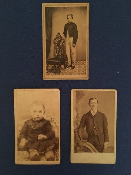 Three CDV images mounted on a dark blue background: a young man standing by a chair, a baby in a dark colored outfit sitting up, and a man with one hand resting on the edge of a piece of furniture. 