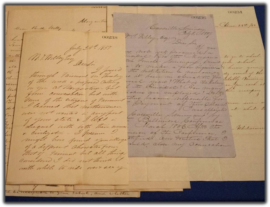 several documents with neat cursive. one is a light lavender color. 