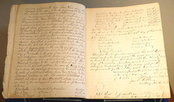 A book opened to a two page spread. Both pages are filled with neat cursive. This is the original articles of incorporation and stockholders minute book to Storer College.