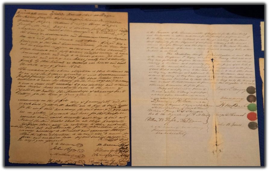 Two documents side by side. the on on the left is yellowed and covered with cursive. the one on the right is lighter in color and end with signatures next to wax seals 